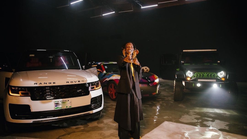 Seyi Vibez poses with his collection of cars